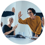 Team sitzt gemeinsam am Tisch und lacht – Emotion Zugehörigkeit und Gemeinschaft im Employer Branding.