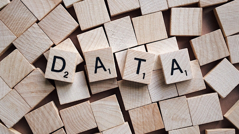 Holzbuchstaben formen das Wort „DATA“ und symbolisieren die Bedeutung von Daten, Analyse und strukturiertem Wissen in modernen Geschäftsprozessen.